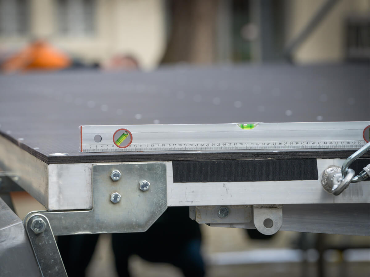 Ausrichten von Bühnenboden mit Wasserwaage